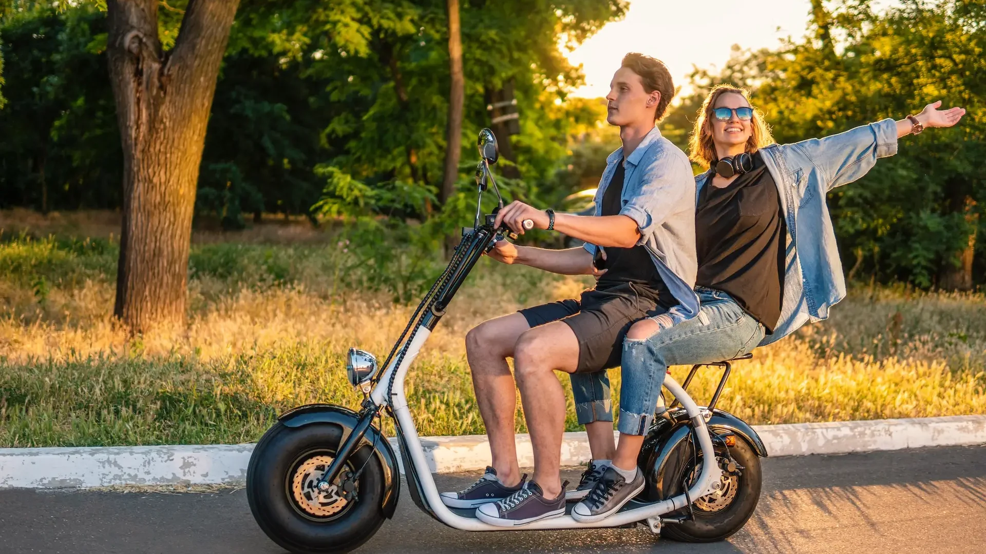 Lovely young couple driving electric bike during summer Modern city life and transportation