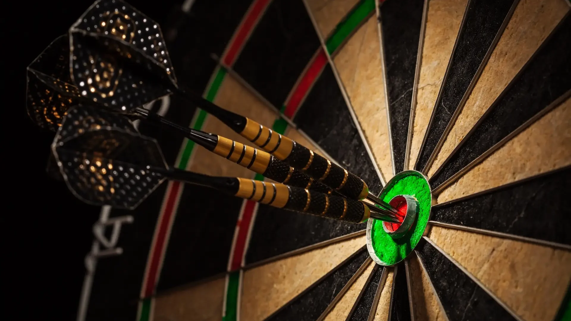 Success hitting target aim goal achievement concept background - three darts in bull's eye close up